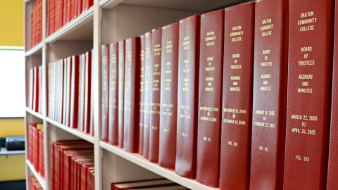 Multiple rows of red hardcover books labeled Oakton Community College. 